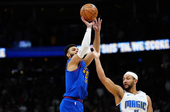 Jalen Suggs attempting to block a shot by Jamal Murray.